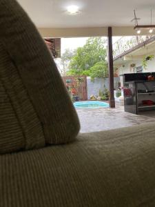 a couch in a living room with a view of a pool at Paraíso do santinho in Florianópolis