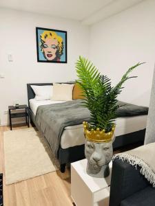 ein Schlafzimmer mit einem Bett mit einer Pflanze in einem Topf in der Unterkunft Ferienwohnung COCO Ochsenfurt in Ochsenfurt