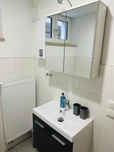 ein weißes Badezimmer mit Waschbecken und Spiegel in der Unterkunft Ferienwohnung COCO Ochsenfurt in Ochsenfurt