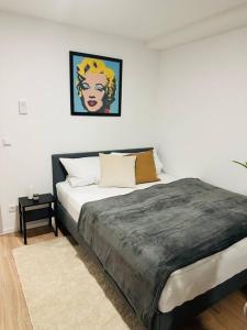 ein Schlafzimmer mit einem Bett und einem Gemälde an der Wand in der Unterkunft Ferienwohnung COCO Ochsenfurt in Ochsenfurt