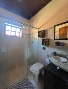 uma casa de banho com um chuveiro, um WC e um lavatório. em Refúgio da Mantiqueira em Passa Quatro