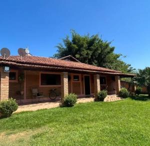 a small brick house with a grass yard at Refúgio da Mantiqueira in Passa Quatro