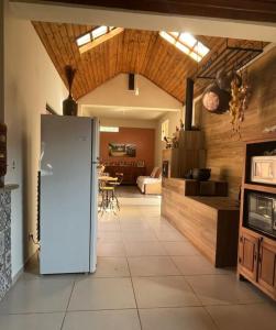 a kitchen with a refrigerator and a living room at Refúgio da Mantiqueira in Passa Quatro