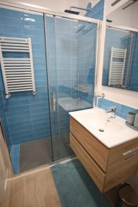 baño con lavabo y ducha con azulejos azules en Forever Home in Naples, en Nápoles