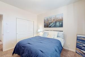 Un dormitorio con una cama azul con una pintura en la pared en Oro Oasis, en El Paso