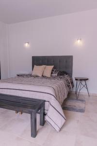 a bedroom with a large bed with a bench on it at Aires de Altura y Singani in Tarija