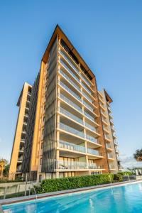 bâtiment en aominium avec piscine en face dans l'établissement Oaks Redcliffe Mon Komo Suites, à Redcliffe