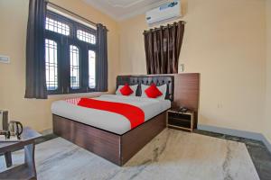 1 dormitorio con 1 cama grande con almohadas rojas en Flagship Hotel Elite Inn, en Jaipur