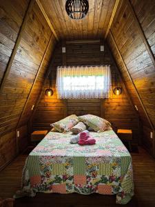 a bedroom with a bed in a wooden attic at Chalé de Madeira em Vargem Alta in Vargem Alta
