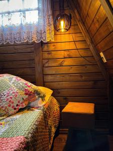 a bedroom with a bed and a window and a lamp at Chalé de Madeira em Vargem Alta in Vargem Alta +30 photos