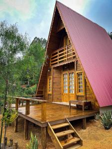 a wooden house with a red roof at Chalé de Madeira em Vargem Alta in Vargem Alta