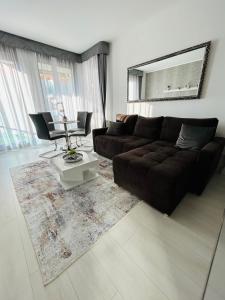 ein Wohnzimmer mit einem schwarzen Sofa und einem Tisch in der Unterkunft Marina Bay Apartman in Budapest