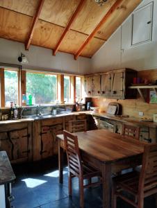 uma cozinha com uma mesa de madeira e armários de madeira em Casa de campo al lado de la ciudad 130 mts2 em Valdivia