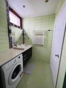 ein Badezimmer mit einer Waschmaschine und einem Waschbecken in der Unterkunft Marina Bay Apartman in Budapest