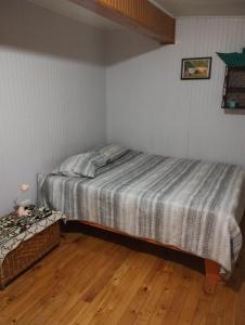 a bedroom with a bed and a wooden floor at Casa de campo al lado de la ciudad 130 mts2 in Valdivia