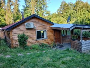 a log cabin with a porch and a roof at Cabaña en parcela a 5 minutos de Valdivia in Valdivia