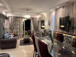 a living room with a table and chairs and a television at شقه فندقيه فى قلب عباس العقاد مدينه نصر احجز ٣ ايام وتمتع بجوله سياحيه لاهرامات الجيزة in Cairo