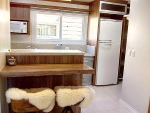 a kitchen with a sink and a white refrigerator at Casa Residencial Samira. Junto ao Centro. in Canela