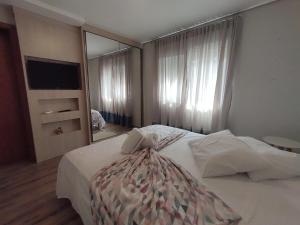 a bedroom with a large bed and a large mirror at Casa Residencial Samira. Junto ao Centro. in Canela