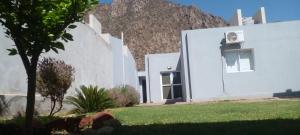 a white house with a mountain in the background at Casa en Chilecito equipada cerca ruta 40 in Chilecito