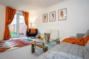 Una sala de estar con una cama y una mesa de cristal. en Entire House in Ipswich, en Ipswich