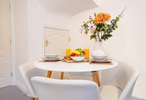 uma mesa de jantar branca com um vaso de flores em Entire House in Ipswich em Ipswich