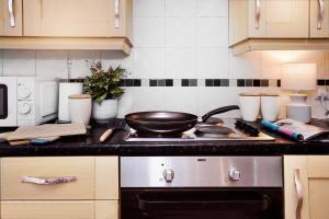 a kitchen with a stove with a frying pan on it at Entire House in Ipswich in Ipswich