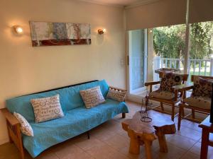 sala de estar con sofá azul y mesa en DEPARTAMENTO MARAVILLOSA VISTA A JARDINES BAHIA PELICANOS, en Puchuncaví