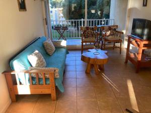 a living room with a couch and a table at DEPARTAMENTO MARAVILLOSA VISTA A JARDINES BAHIA PELICANOS in Puchuncaví