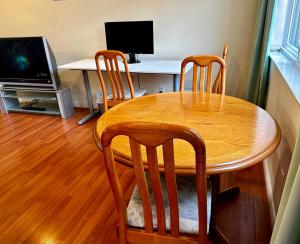 溫哥華的住宿－SixPine Suite，一张带四把椅子的木桌和一张带电脑的桌子