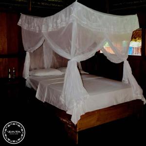a bedroom with a bed with a canopy at Waita Lodge in Cuyavenus