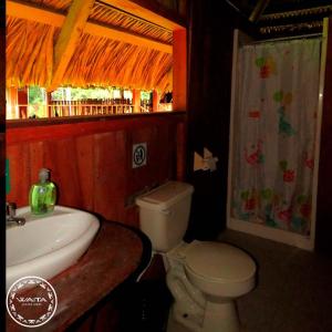 a bathroom with a sink and a toilet and a window at Waita Lodge in Cuyavenus