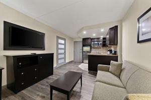 a living room with a couch and a flat screen tv at Best Western Plus Toronto North York Hotel & Suites in Toronto