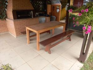 una mesa de picnic de madera y un banco en un patio en RESIDENCIA DOS MAFRA - Piso Térreo e RESIDENCIA DOS MAFRA - Piso Superior, en Campos do Jordão