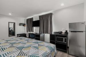 a hotel room with a bed and a refrigerator at Studio 6 Suites Perris, CA in Perris