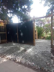 a large black gate in a yard with a fence at Hermosa cabaña con huerta - Casa verde in Medellín