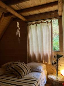 a bed in a room with a window and a bed sidx sidx sidx at Hermosa cabaña con huerta - Casa verde in Medellín