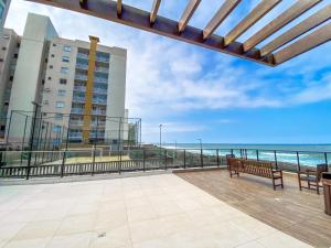 a balcony with benches and a view of the ocean at Resort em Barra velha, pé na areia e vista mar in Barra Velha