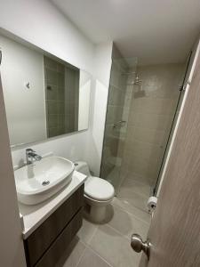een badkamer met een wastafel, een toilet en een douche bij Apartamento en el poblado vista a todo Medellín. in Medellín