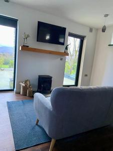 a living room with a couch and a flat screen tv at Bill's Barns, Apartment 1 in Kenmare