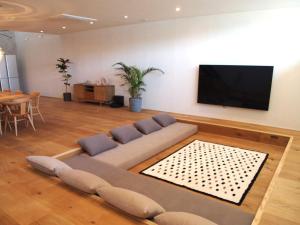 a living room with a couch and a flat screen tv at 小豆島の貸切宿　おぼろととろろ　【最大10名様】【一日一組限定】【瀬戸内オーシャンフロントのお宿】 in Shodoshima