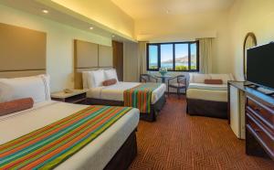 Habitación de hotel con 2 camas y TV de pantalla plana. en Sonesta Posadas del Inca Puno en Puno