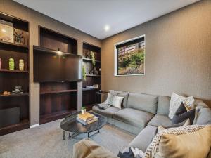 un soggiorno con divano e TV a schermo piatto di Hawthorne House a Queenstown