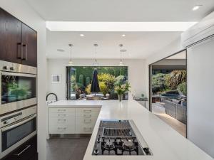 a kitchen with white counters and a stove top oven at Hawthorne House in Queenstown