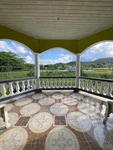 an ornate balcony with a view of the countryside at Veronica Homestay Lucea Jamaica in Lucea