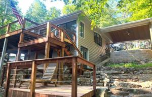 a house with a deck and a staircase next to it at Lakefront Home Serene Views & Deck Near Mammoth Cave in Fentress McMahan
