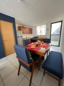 a kitchen with a wooden table and blue chairs at Excelente para no rentar in Guadalajara