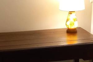 una lampada posta sopra un tavolo di legno di Appartamento In Centro Tradate a Tradate