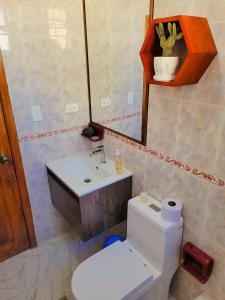 a bathroom with a white toilet and a sink at Casa Cuscungo Family Experience in Quito