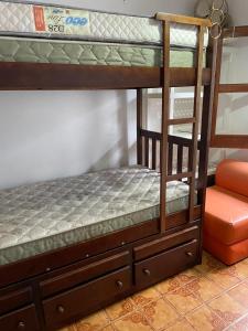 a bunk bed with a ladder on top of it at Apartamento para Temporada Ubatuba in Ubatuba